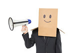 Businessman with box on head holding megaphone