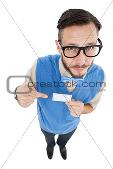 Geeky hipster looking at camera pointing at card