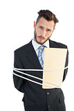 Serious businessman tied up at work