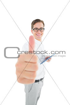 Geeky businessman holding his tablet showing thumbs up