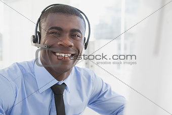 Happy businessman working at his desk wearing headset