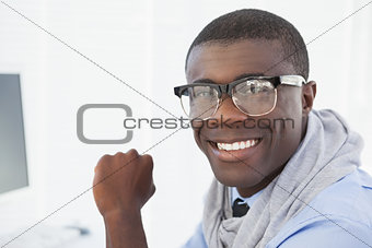 Hipster businessman smiling at his desk