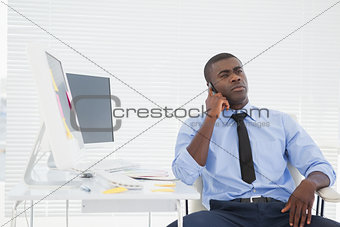 Businessman sitting at his desk on the phone