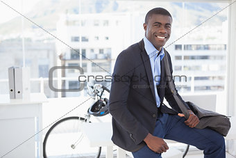Smiling businessman with his bicycle