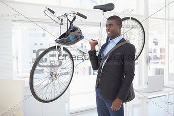 Happy businessman carrying his bicycle