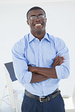 Happy businessman standing with arms crossed
