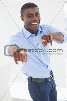 Happy businessman pointing at camera