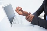 Businessman holding his sore wrist from typing