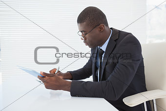 Serious businessman working with his tablet