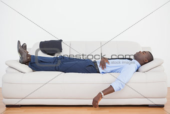 Tired businessman sleeping on the sofa