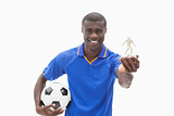 Football player in blue holding ball and figurine