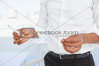 Businessman deciding between electronic or normal cigarette