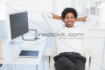 Happy businessman sitting back in his chair