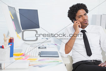 Serious businessman working at his desk on the phone