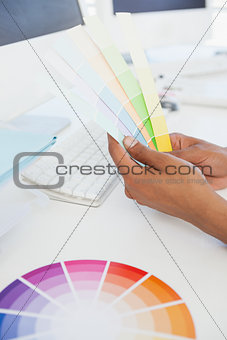 Designer working at desk holding colour samples