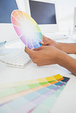 Designer working at desk holding colour wheel
