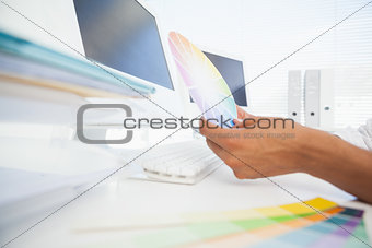 Designer working at desk holding colour wheel