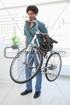 Handsome businessman standing with his bike