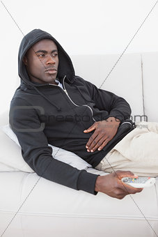 Casual man watching tv on his sofa