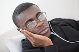Casual man sleeping on his sofa wearing glasses