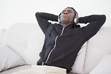 Casual man sitting on his sofa listening to music