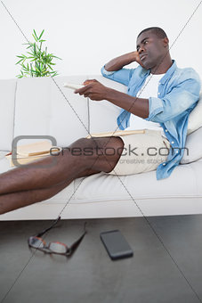 Casual man sitting on sofa watching tv