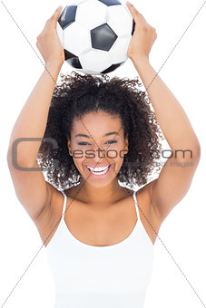 Pretty girl with afro hairstyle smiling at camera holding football