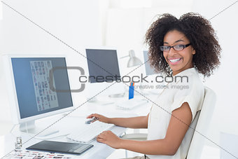Smiling casual editor working at desk