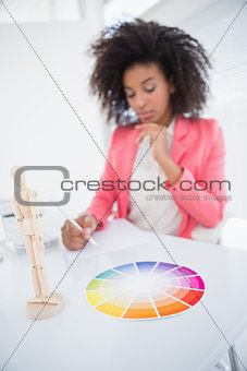 Casual graphic designer working at her desk sketching