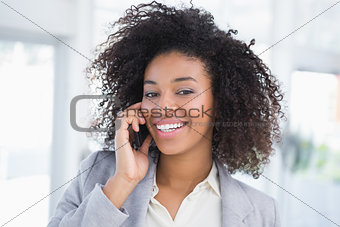 Casual businesswoman talking on phone smiling at camera
