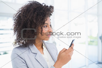 Casual businesswoman texting on phone