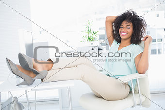 Happy businesswoman sitting with her feet up