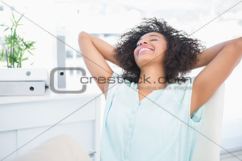 Happy businesswoman relaxing in swivel chair