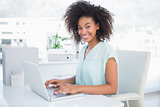 Happy businesswoman working on her laptop