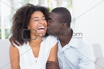 Attractive man kissing his girlfriend on the cheek