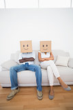 Couple sitting on couch together with boxes over head