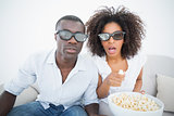 Couple sitting on couch together watching 3d movie