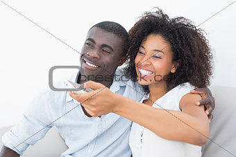Couple sitting on couch together watching tv