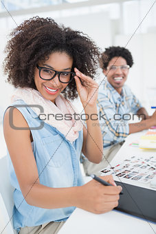 Happy design team working at desk smiling at camera