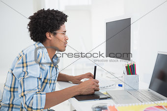 Young designer working at his desk with digitizer