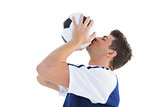 Football player in blue kissing the ball