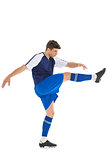Football player in blue jersey kicking