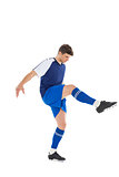 Football player in blue jersey kicking
