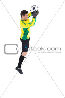 Goalkeeper in yellow making a save