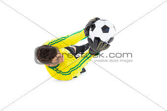 Goalkeeper in yellow holding ball