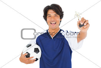 Football player in blue holding winners trophy