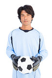 Goalkeeper in blue holding ball