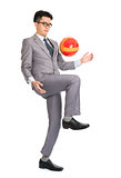 Asian businessman playing soccer 