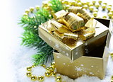 golden gift box with beautiful ribbon in the snow, christmas still life