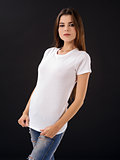 Woman with blank white shirt over black background